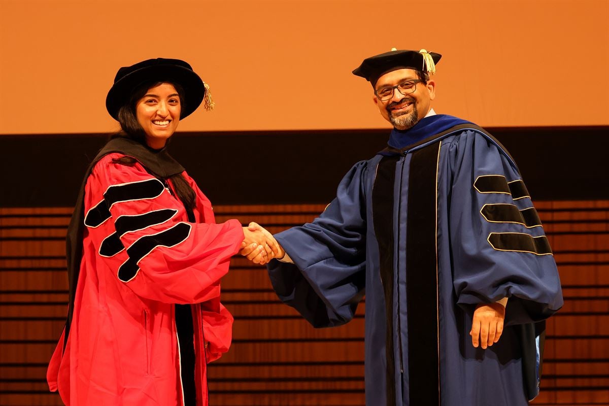 Doctoral graduate shakes hands with Dean of Engineering Shekhar Garde.
