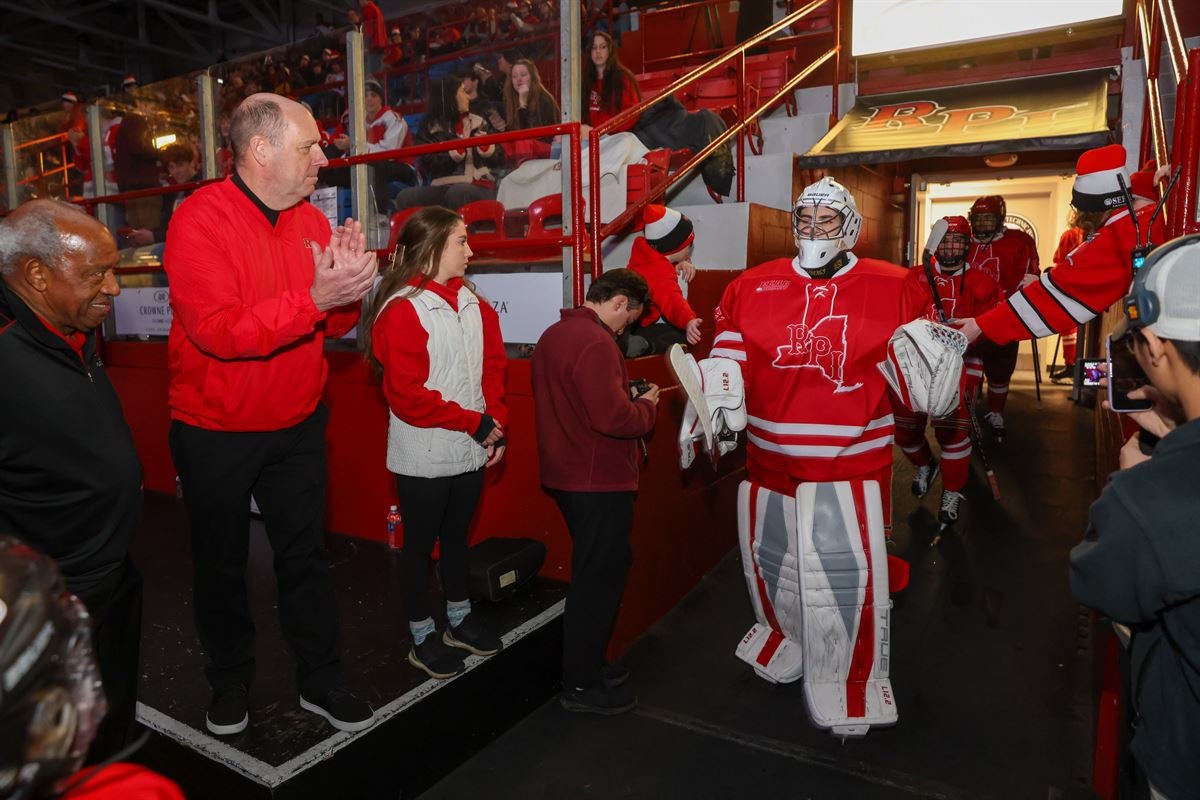 President Marty Schmidt greeting hockey players emerging on the ice at the Field House.