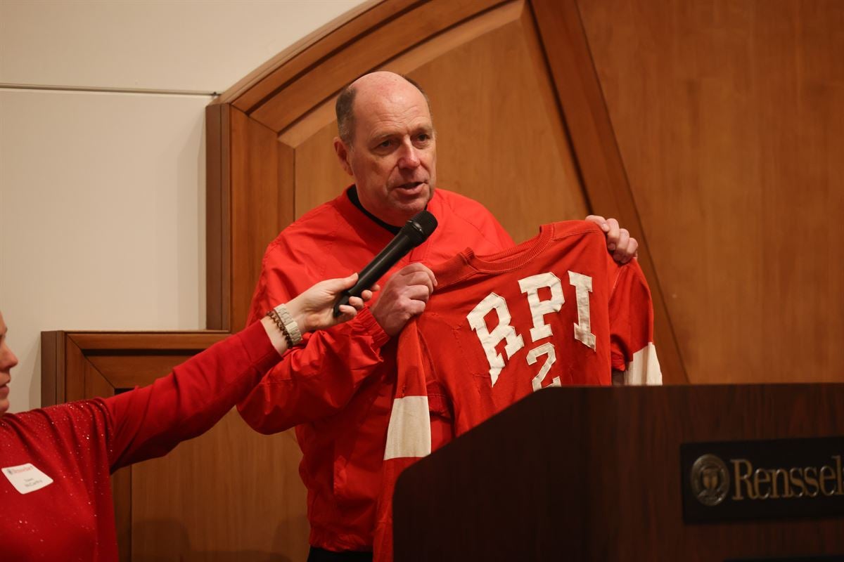 President Marty Schmidt holding an RPI hockey jersey at the post-game Big Red Freakout Ice House.