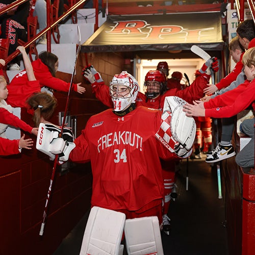 RPI goalie entering the rink flanked by fans