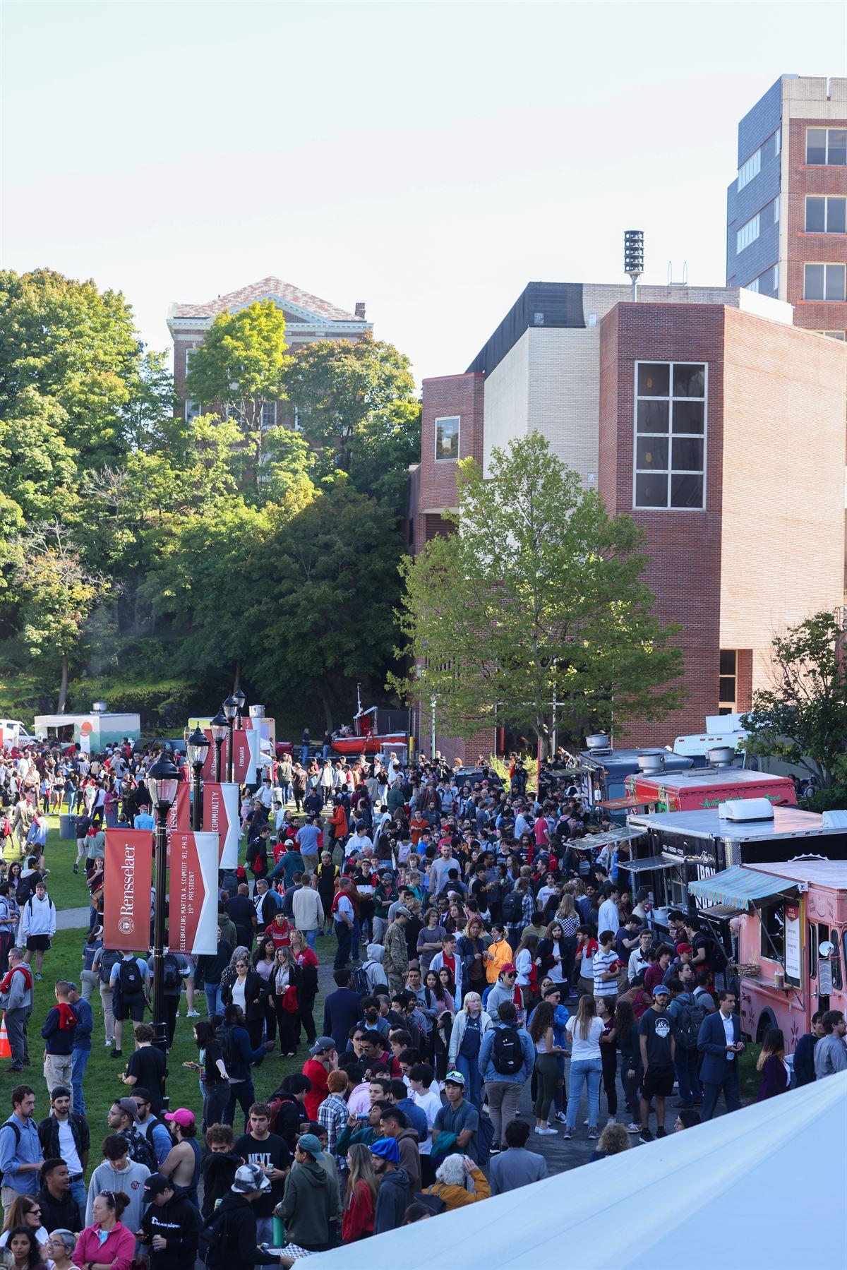 View of crowds visiting food trucks on ’86 Field.