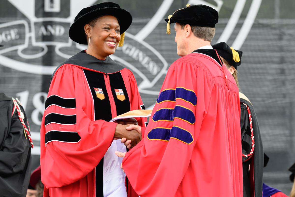 Shayla Sawyer shakes hands with Commencement honorary degree recipient Reid Wiseman.