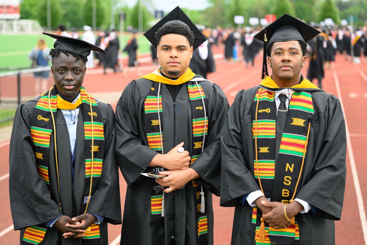 Three graduates wearing National Society of Black Engineers stoles.