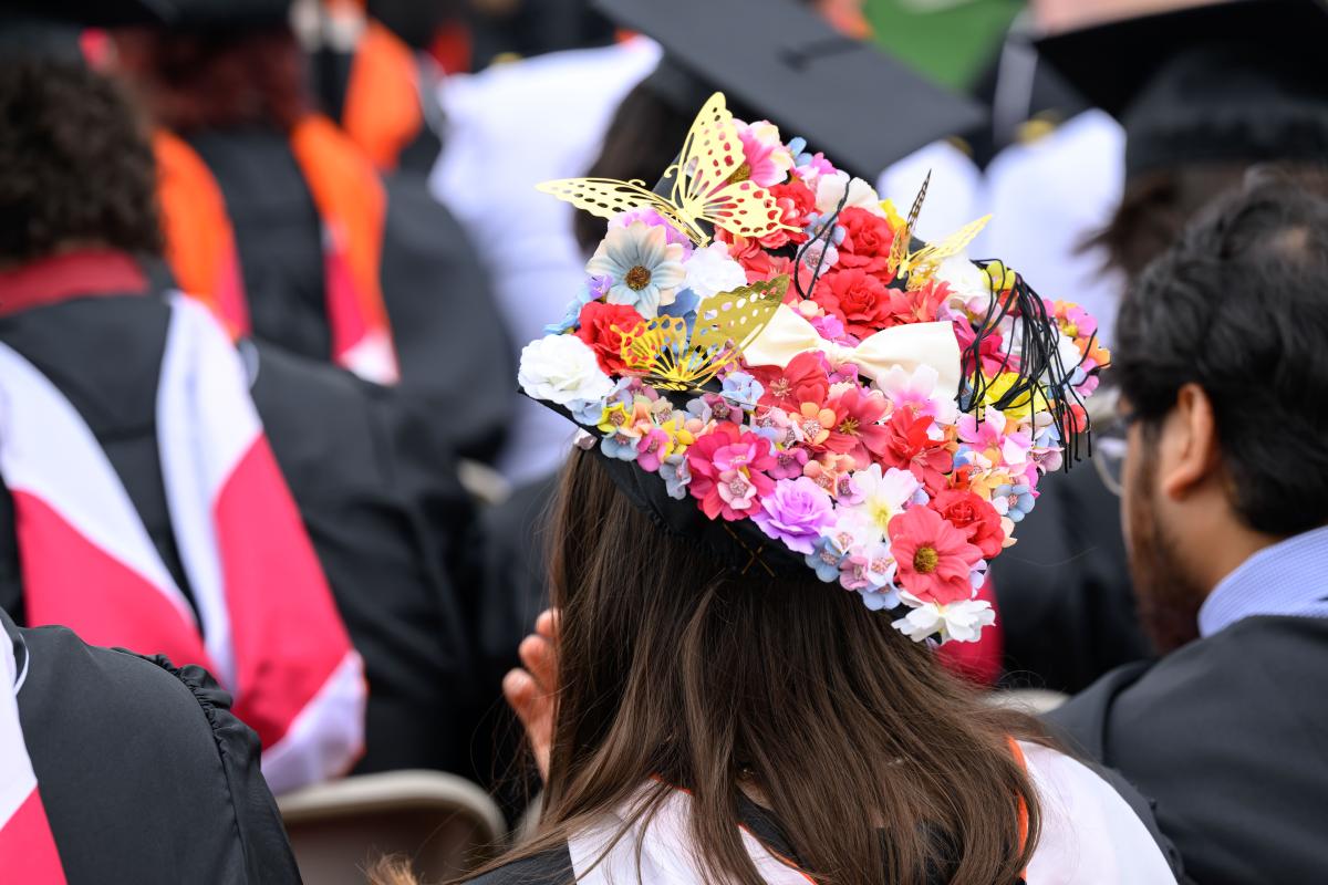 Close-up shot of a graduation cap decorated with flowers and fake butterflies.