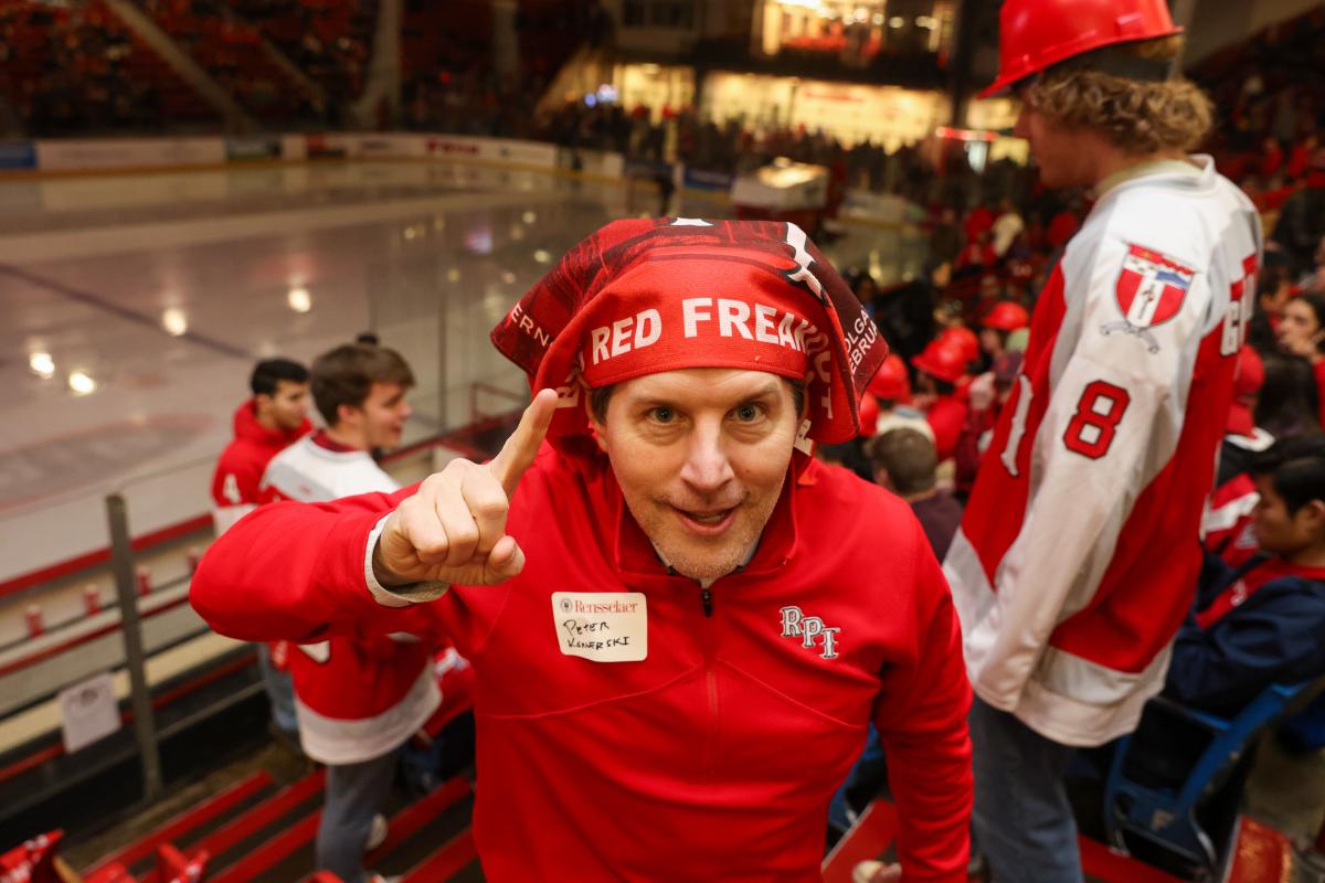 Vice President for Student Life Peter Konwerski at the Big Red Freakout, wearing an RPI shirt and wearing a Big Red Freakout flag on his head.