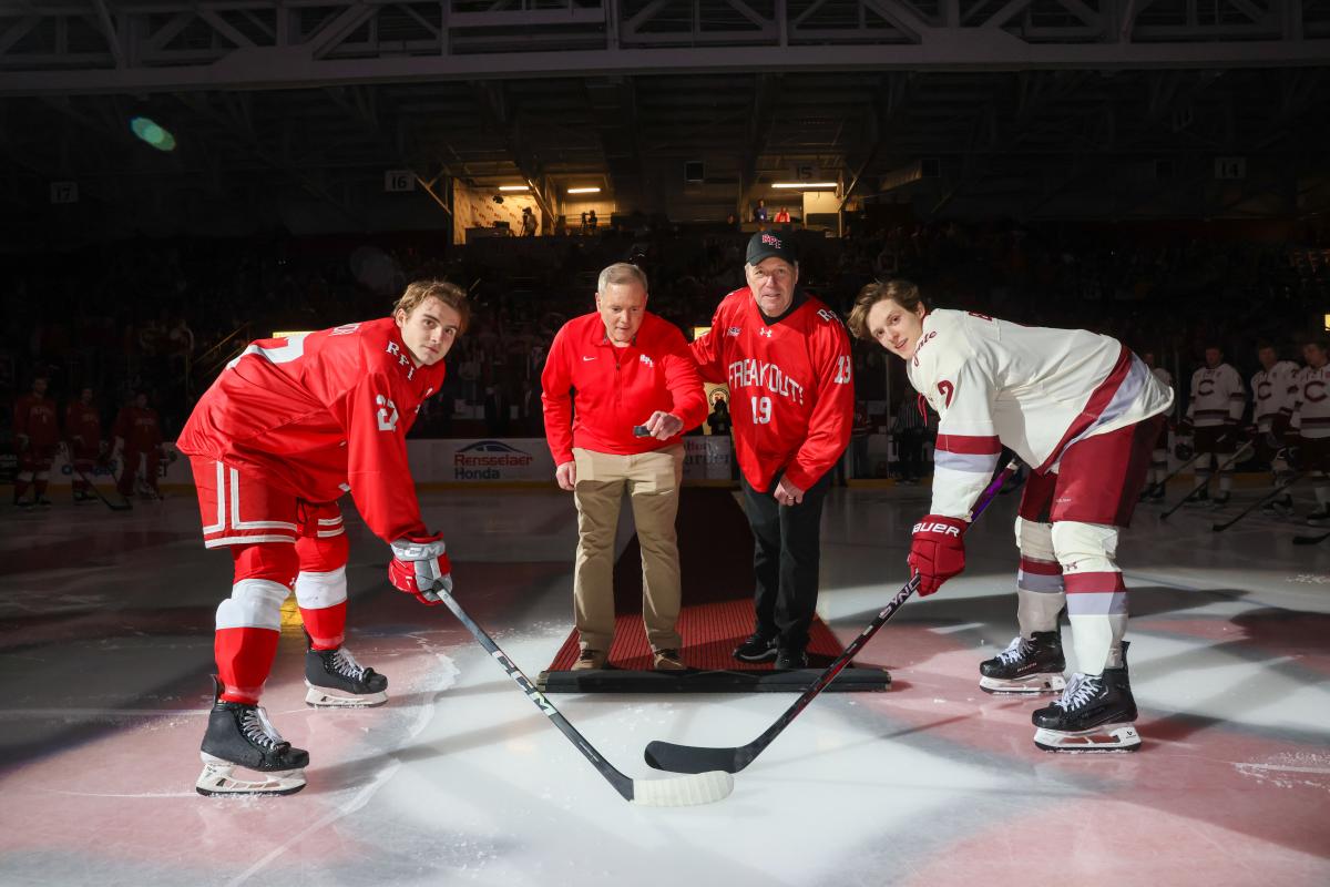 RPI hockey player and Colgate hockey player pose before the ceremonial first puck.