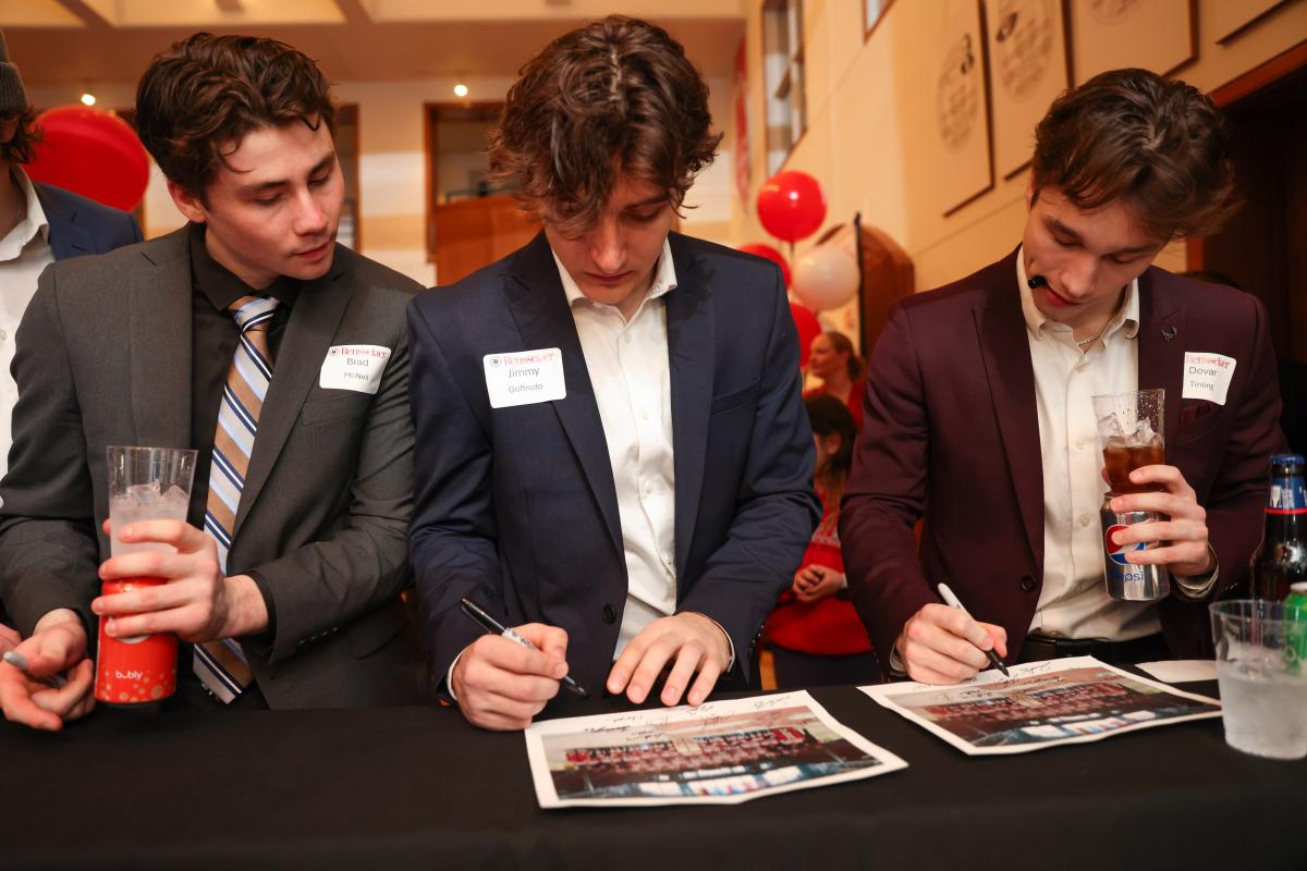 RPI hockey players sign photos at a reception after the Big Red Freakout.