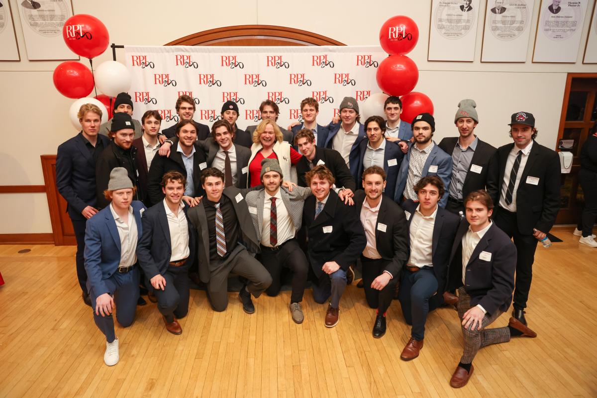 The RPI men's hockey team poses for a photo with Lyn Schmidt, wife of RPI President Martin A. Schmidt.