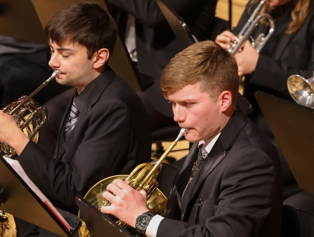 Two student musicians playing french horns during RPI's holiday concert.