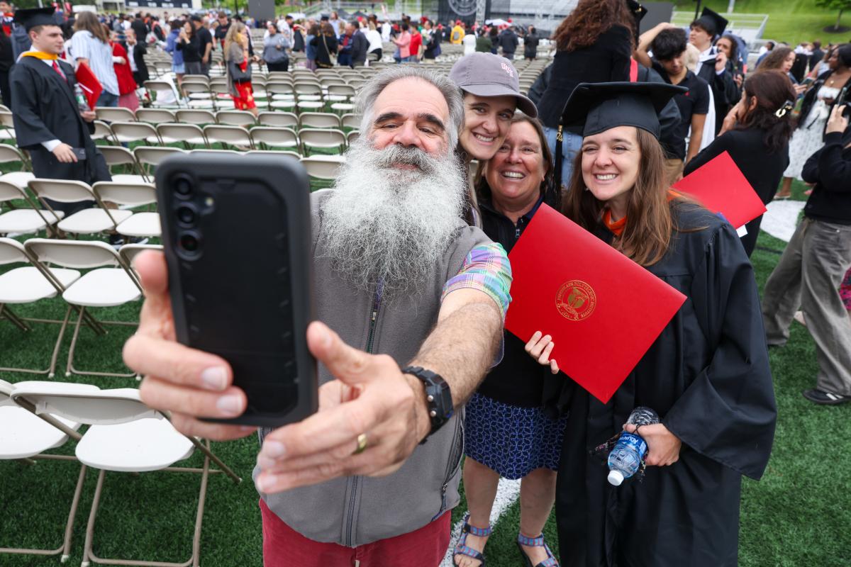 Family taking a cellphone selfie with a graduate after RPI's Commencement ceremony.